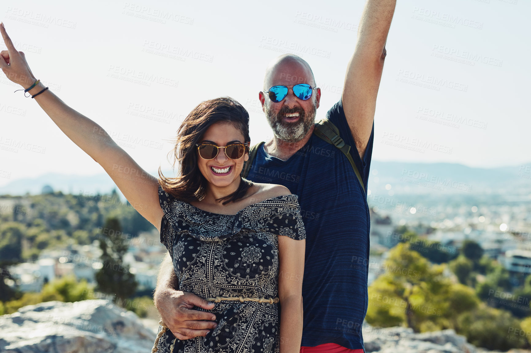 Buy stock photo Outdoor, couple and happy with open arms on hill in portrait for fun, bonding and holiday in Spain. People, relationship and smile with sunglasses for summer vacation, travel and break for freedom