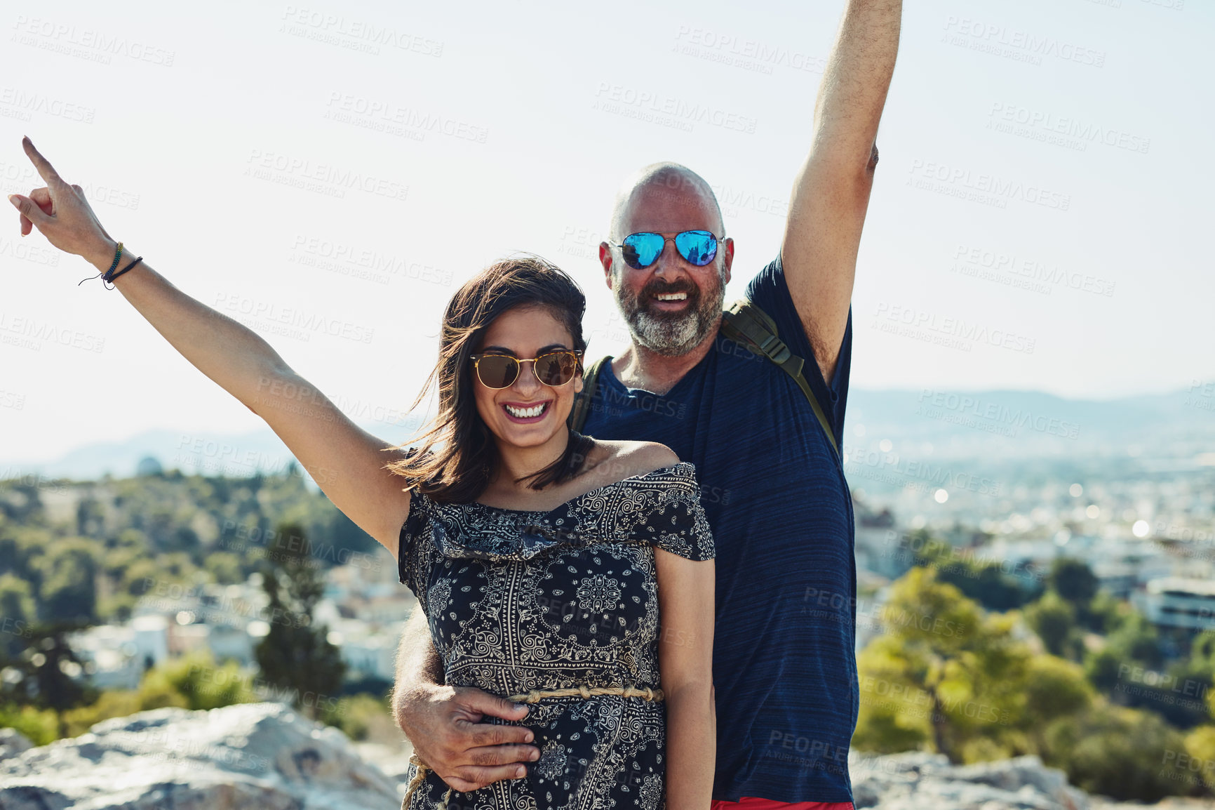 Buy stock photo Outdoor, couple and smile with open arms on hill in portrait for fun, bonding and holiday in Spain. People, relationship and happy with sunglasses for summer vacation, travel and break for freedom