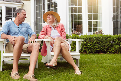 Buy stock photo Mature couple, garden and talking on chair with funny conversation, bonding and care in summer at house. Man, woman and happy with laughing at retirement, relax and chat on grass in home backyard