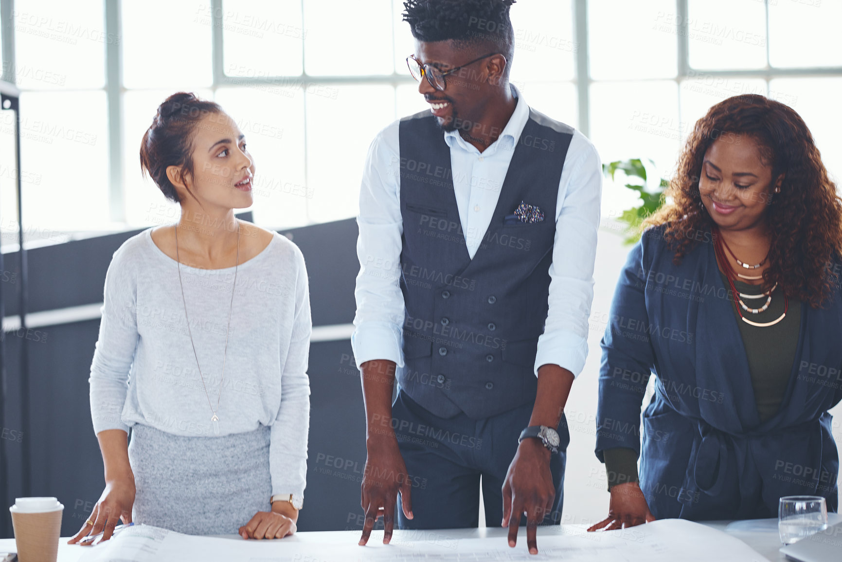 Buy stock photo Cropped shot of a team of professionals working on blueprints in an office