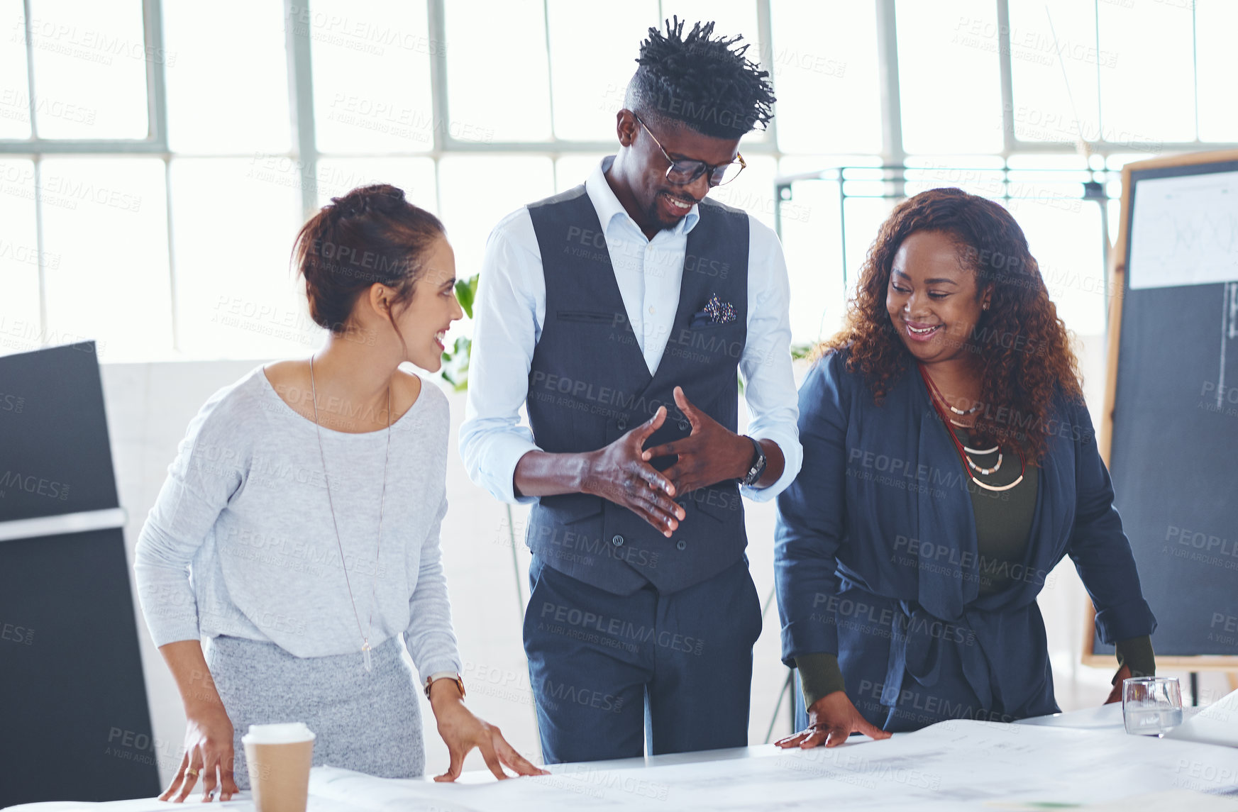 Buy stock photo Cropped shot of a team of professionals working on blueprints in an office