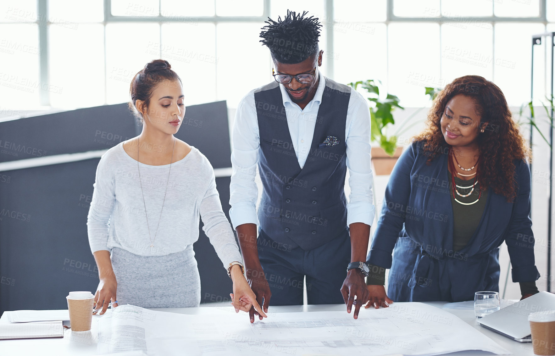 Buy stock photo Cropped shot of a team of professionals working on blueprints in an office