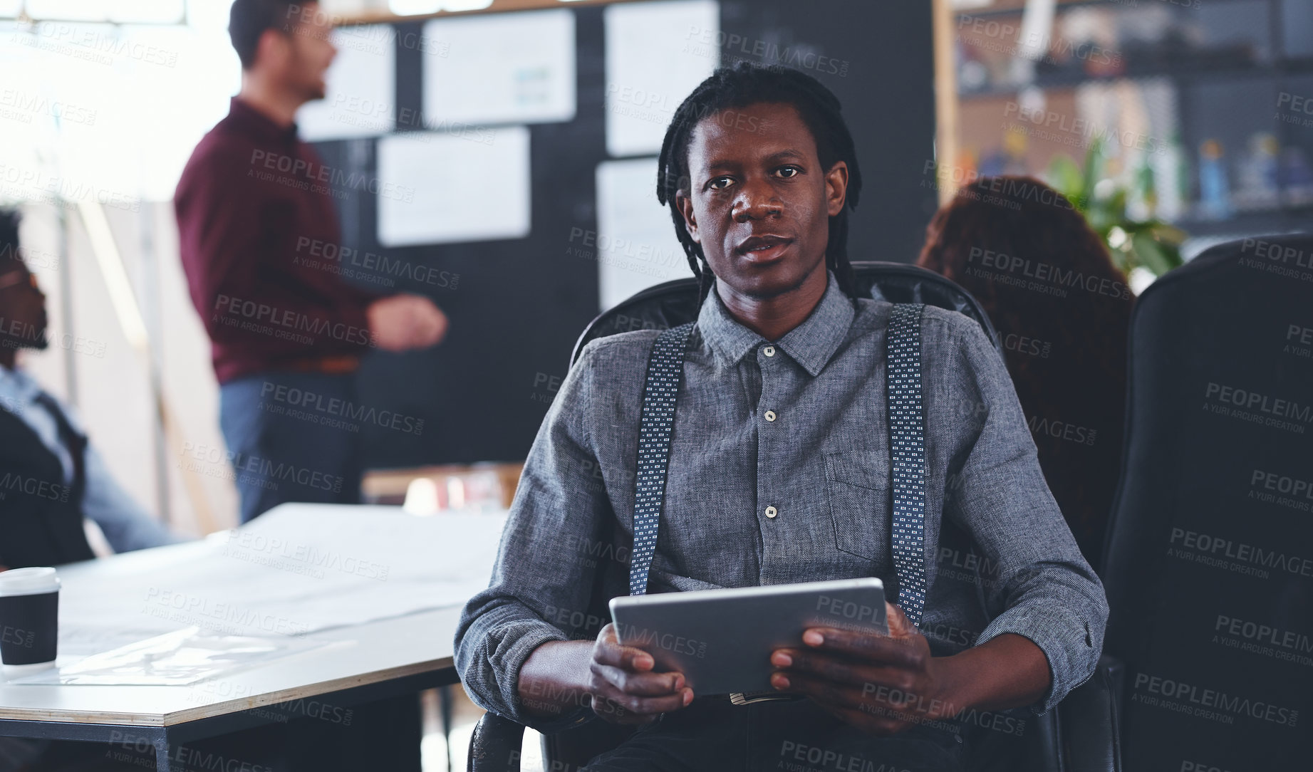 Buy stock photo Portrait of a young businessman using a digital tablet during a meeting in an office