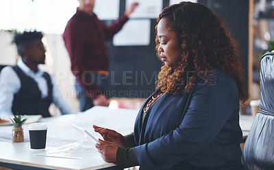 Buy stock photo Shot of a young businesswoman using a digital tablet during a meeting in an office