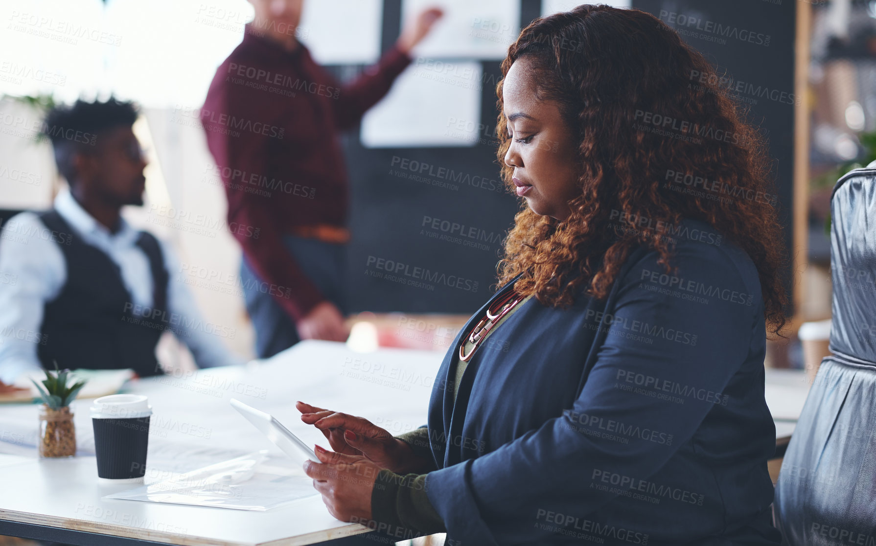 Buy stock photo Shot of a young businesswoman using a digital tablet during a meeting in an office