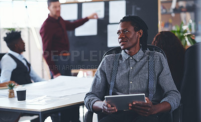 Buy stock photo Shot of a young businessman using a digital tablet during a meeting in an office