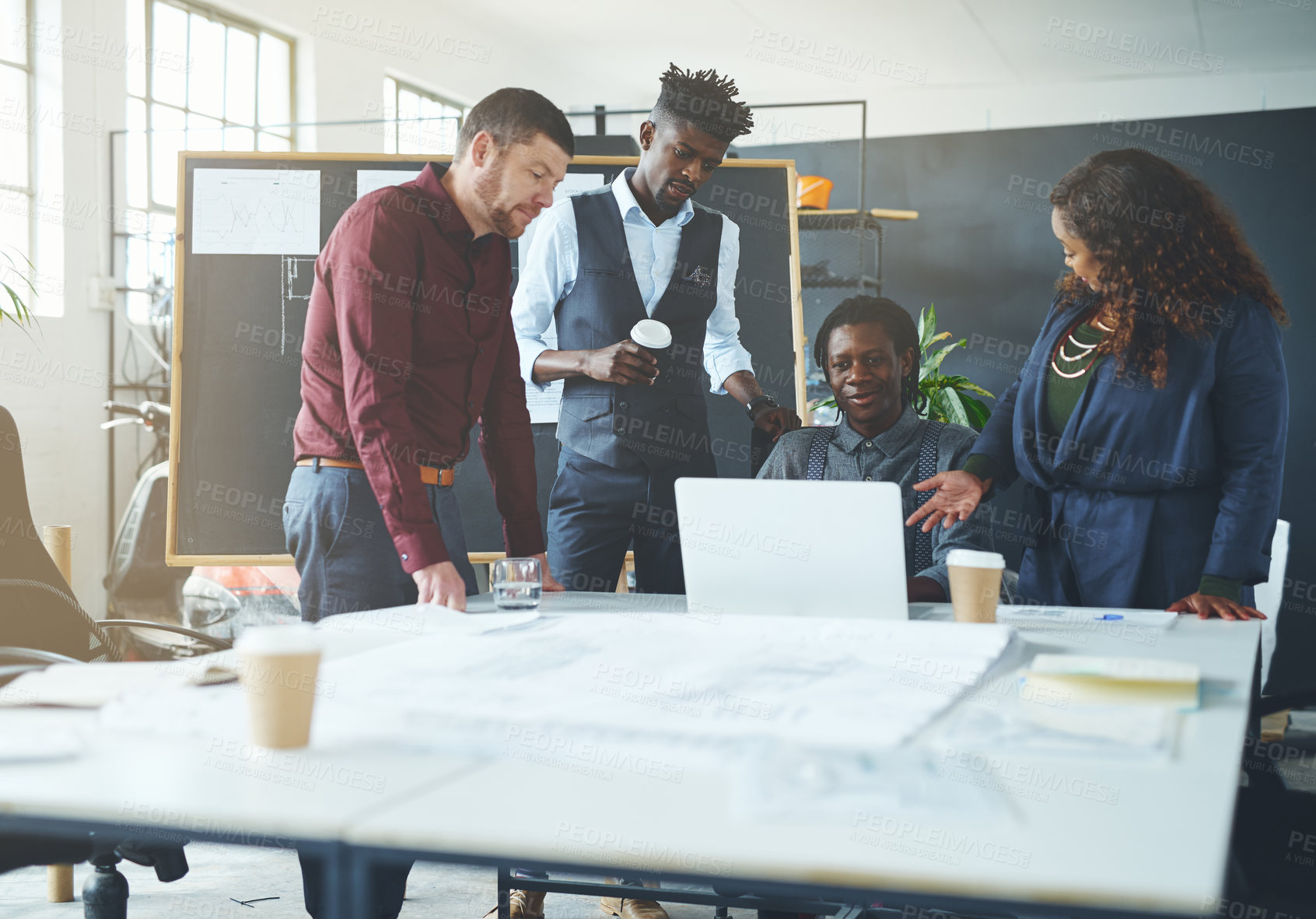 Buy stock photo Shot of a group of coworkers discussing something on a laptop during a meeting