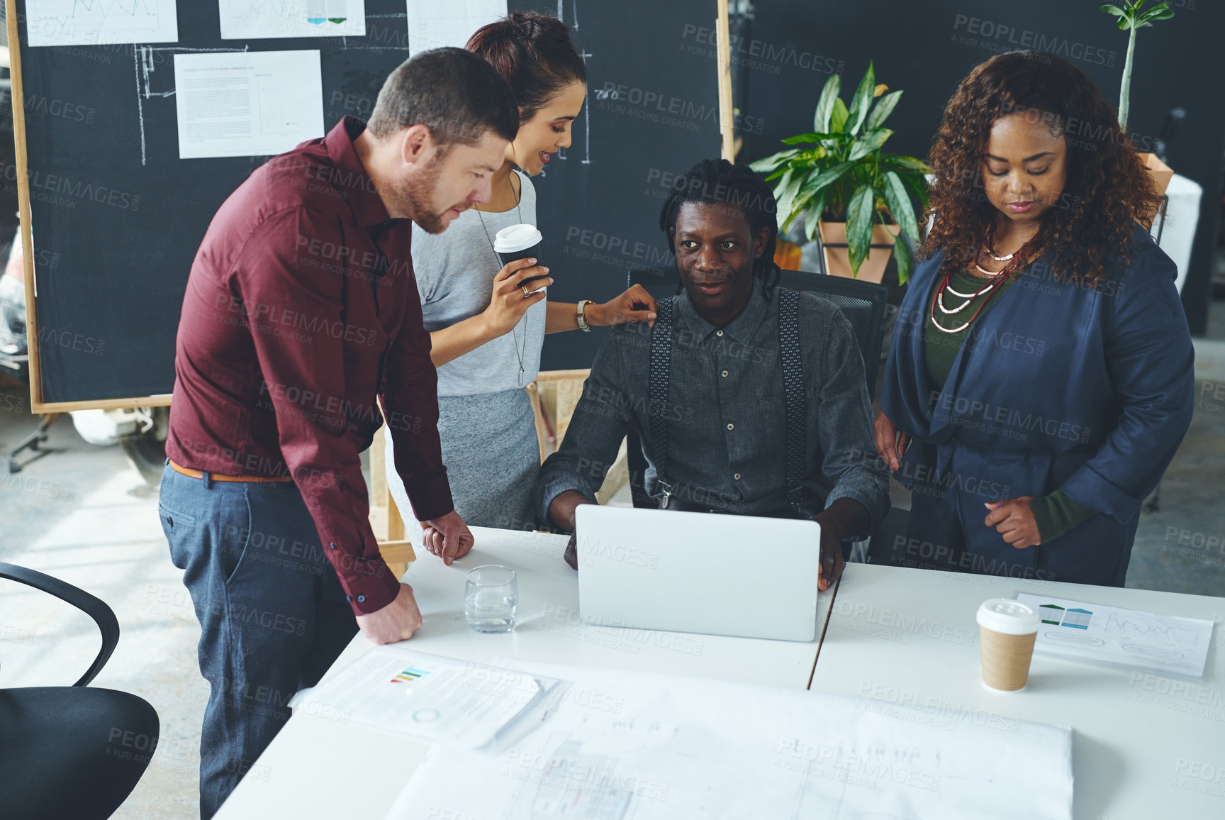 Buy stock photo Shot of a group of coworkers discussing something on a laptop during a meeting