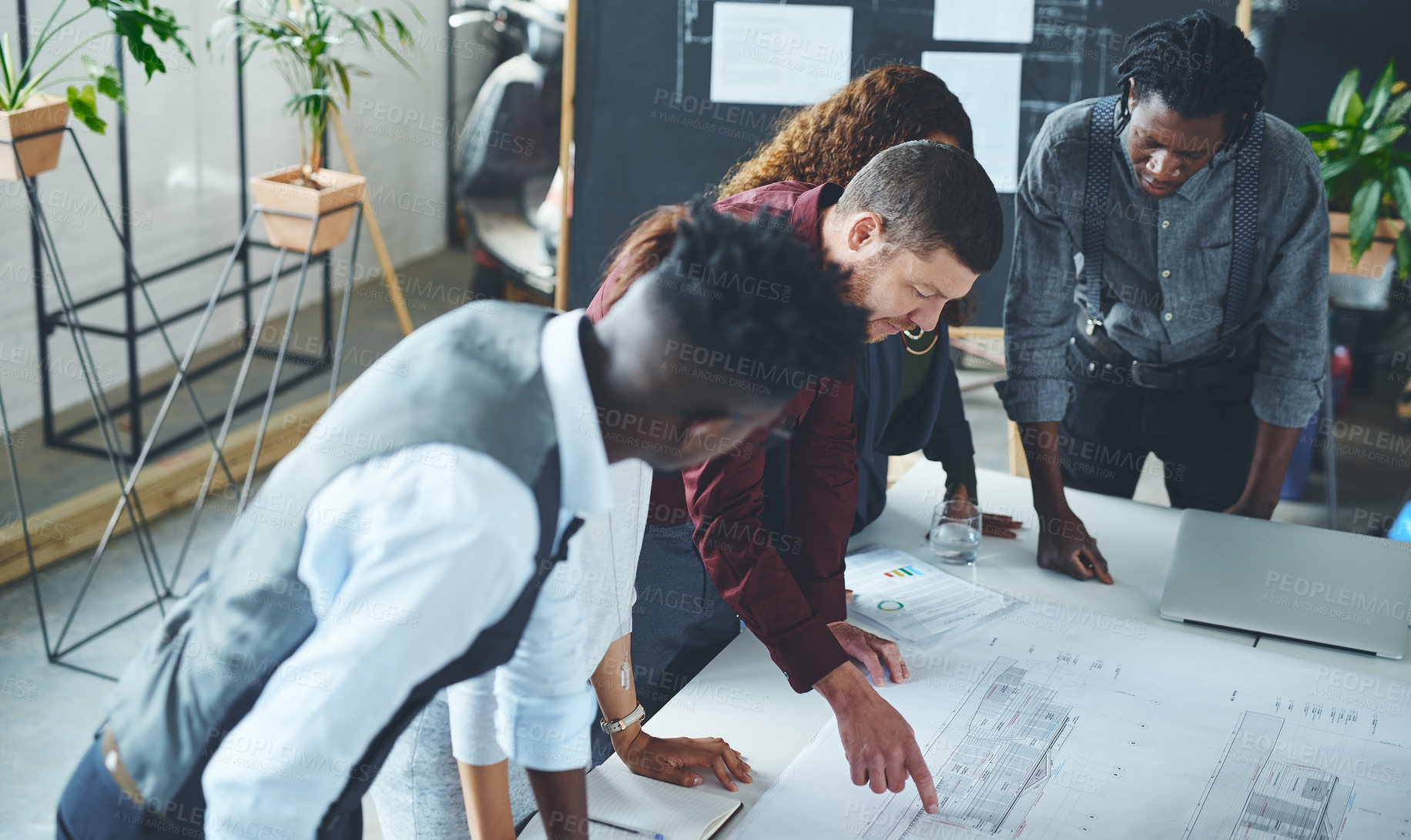 Buy stock photo Cropped shot of a team of professionals working on blueprints in an office