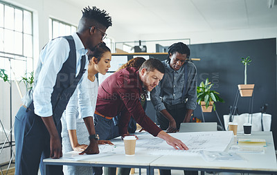 Buy stock photo Cropped shot of a team of professionals working on blueprints in an office