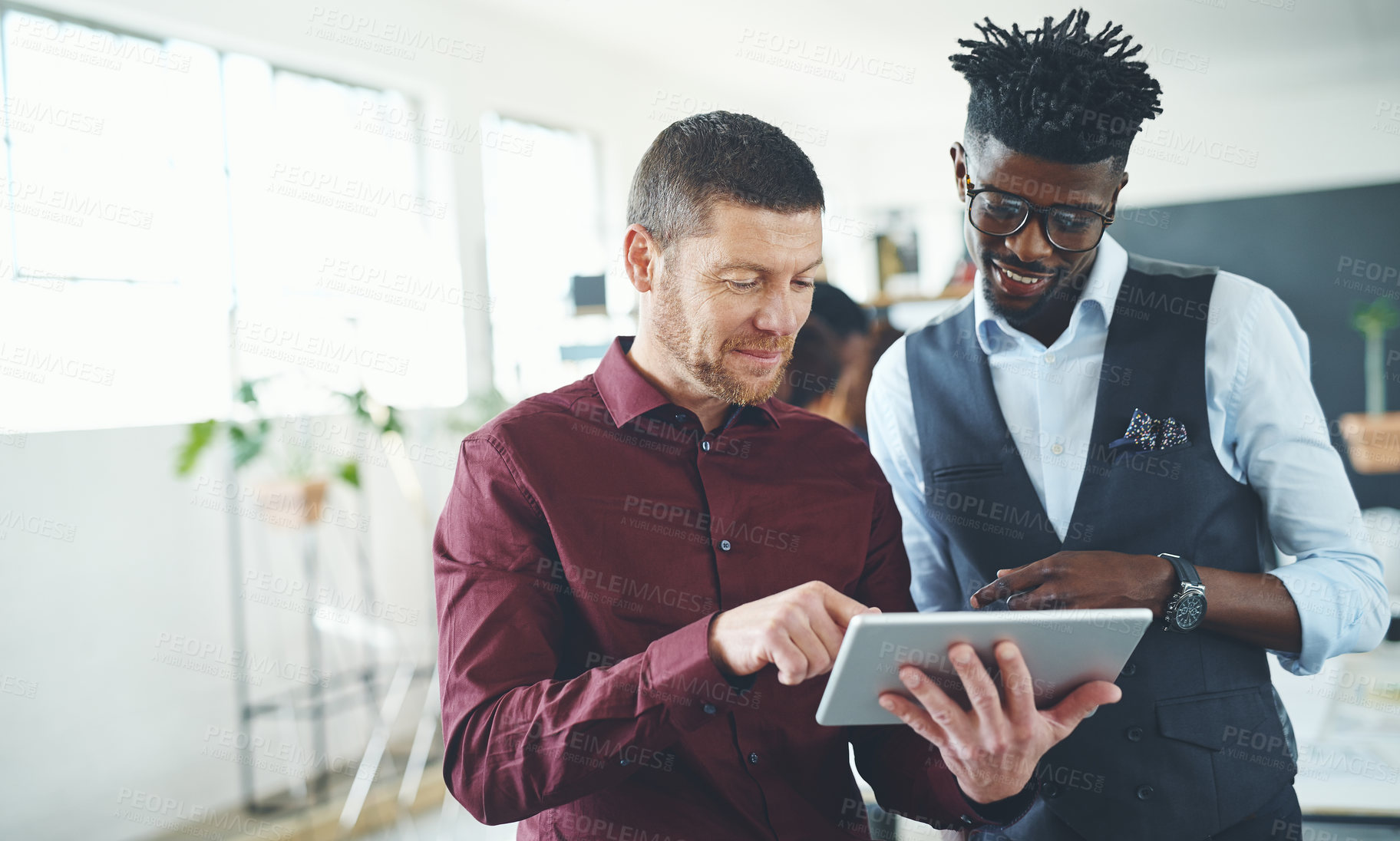 Buy stock photo Cropped shot of two businesspeople working together on a digital tablet in an office