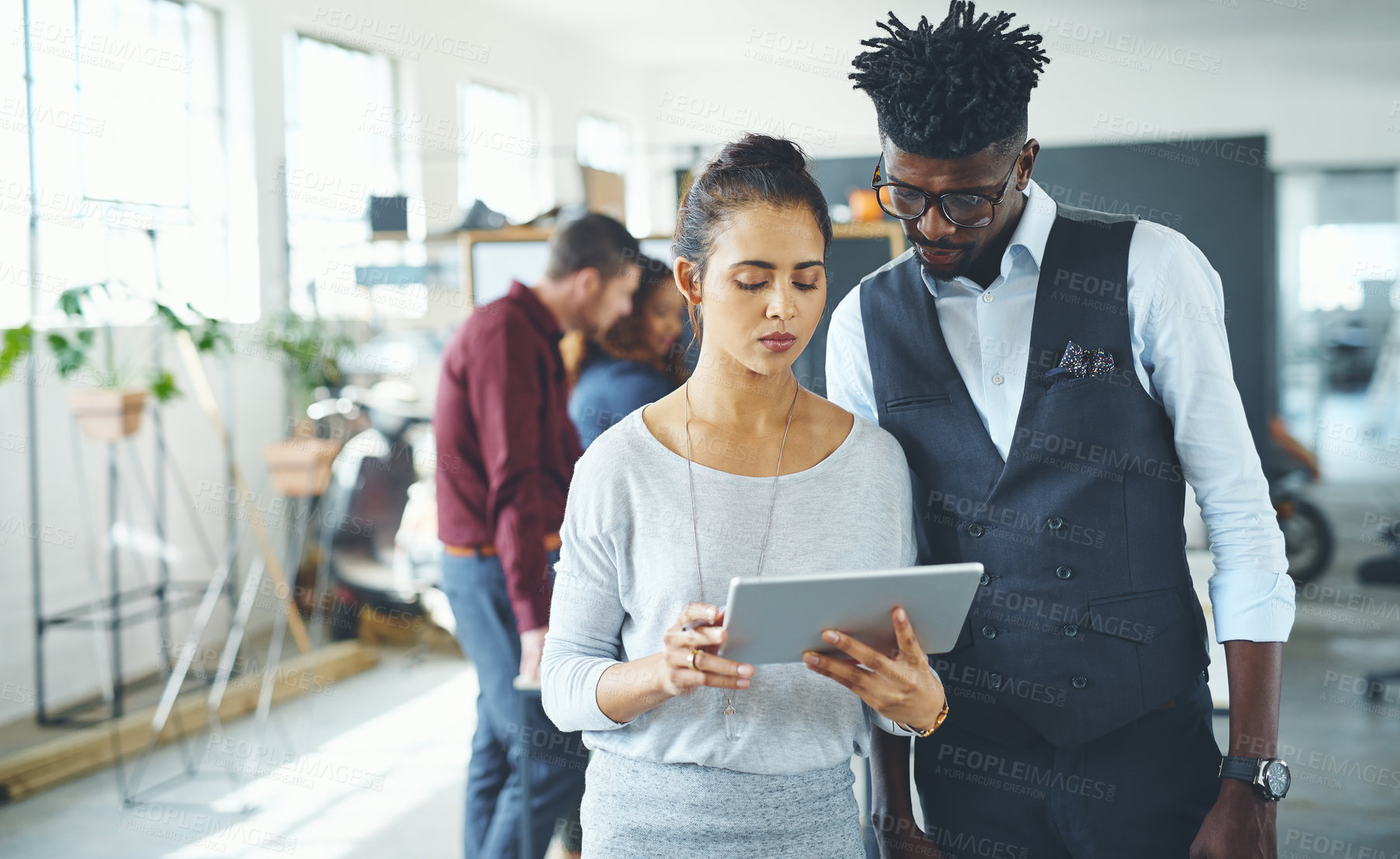 Buy stock photo Cropped shot of two businesspeople working together on a digital tablet in an office