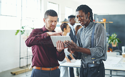 Buy stock photo Cropped shot of two businesspeople working together on a digital tablet in an office