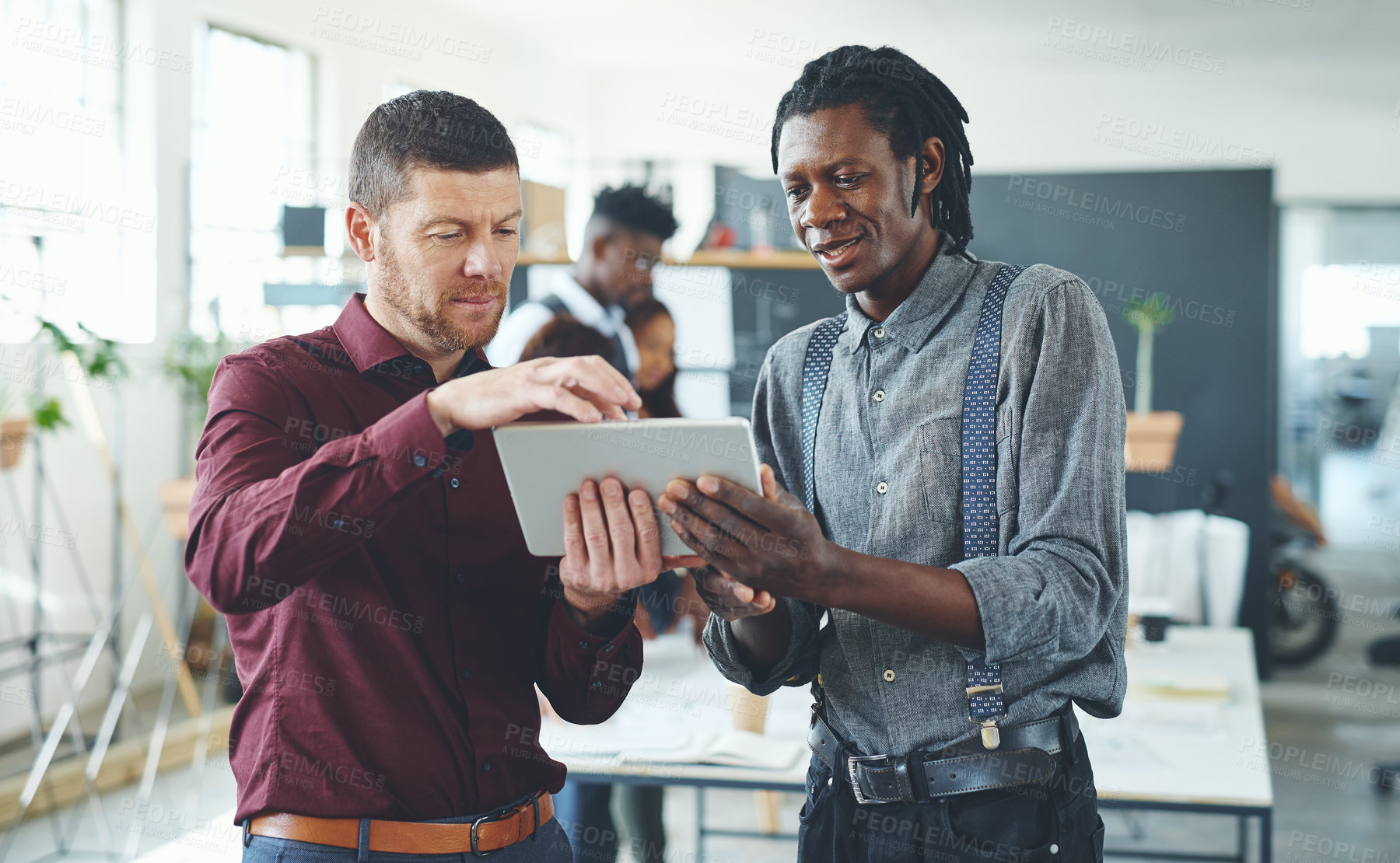 Buy stock photo Cropped shot of two businesspeople working together on a digital tablet in an office