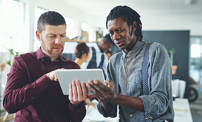 Buy stock photo Cropped shot of two businesspeople working together on a digital tablet in an office