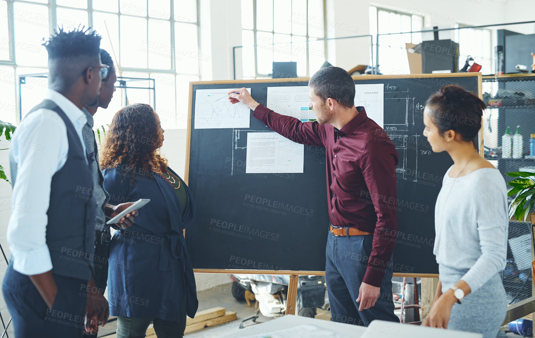 Buy stock photo Shot of a group of businesspeople discussing statistics