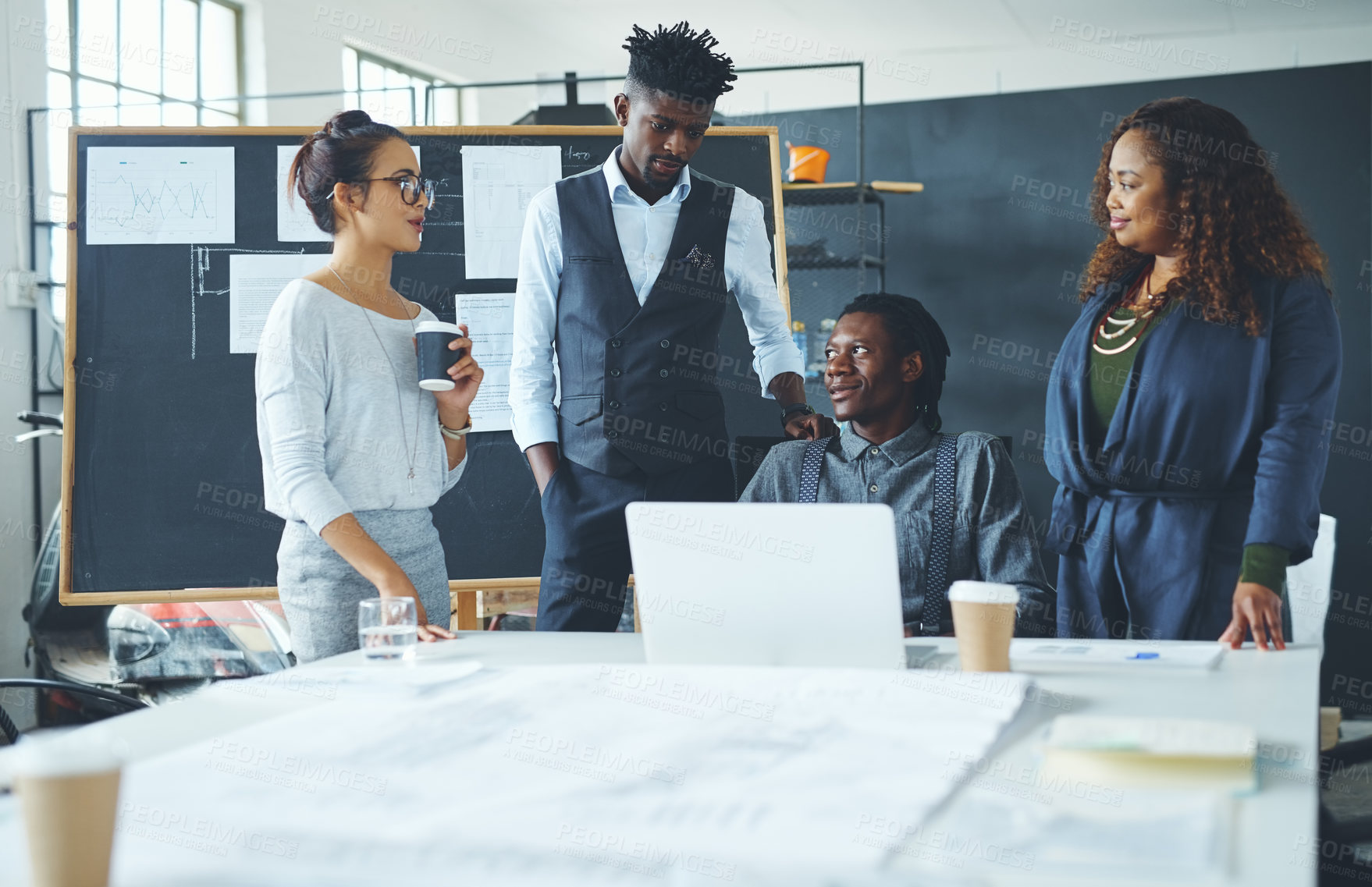 Buy stock photo Shot of a group of coworkers discussing something on a laptop during a meeting