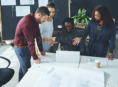 Buy stock photo Shot of a group of coworkers discussing something on a laptop during a meeting