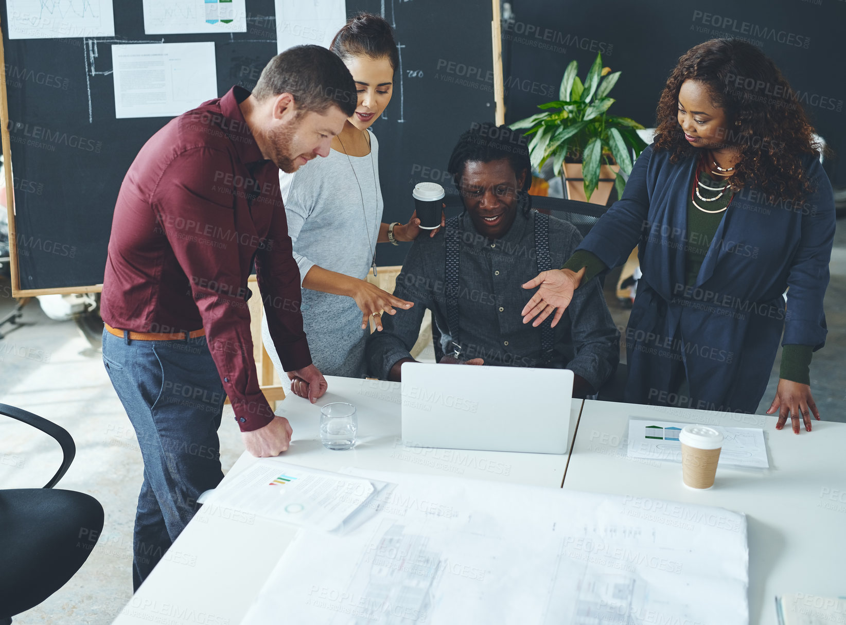 Buy stock photo Shot of a group of coworkers discussing something on a laptop during a meeting