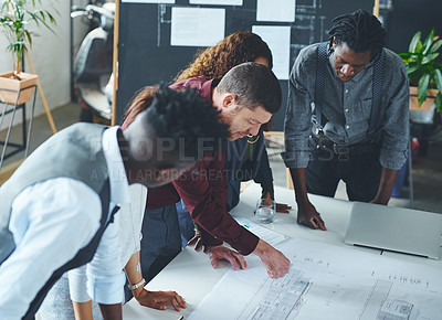 Buy stock photo Cropped shot of a team of professionals working on blueprints in an office