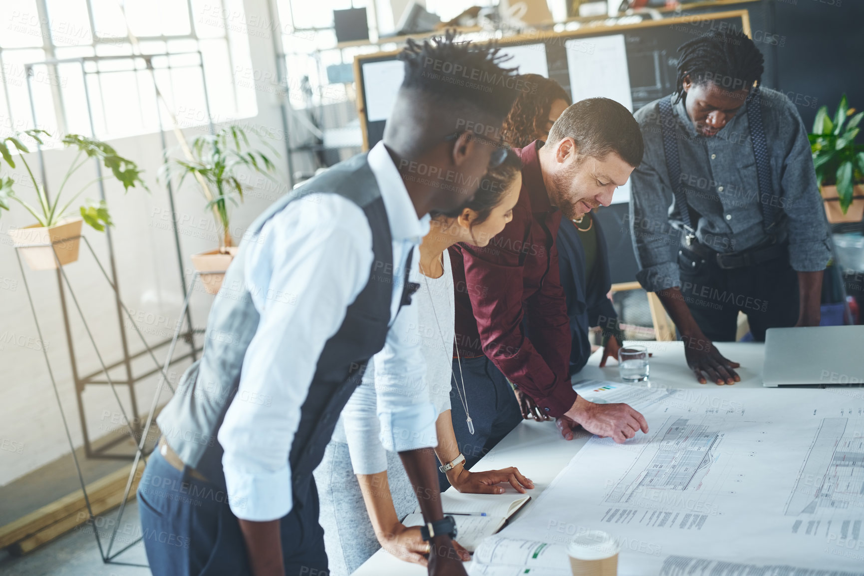 Buy stock photo Cropped shot of a team of professionals working on blueprints in an office