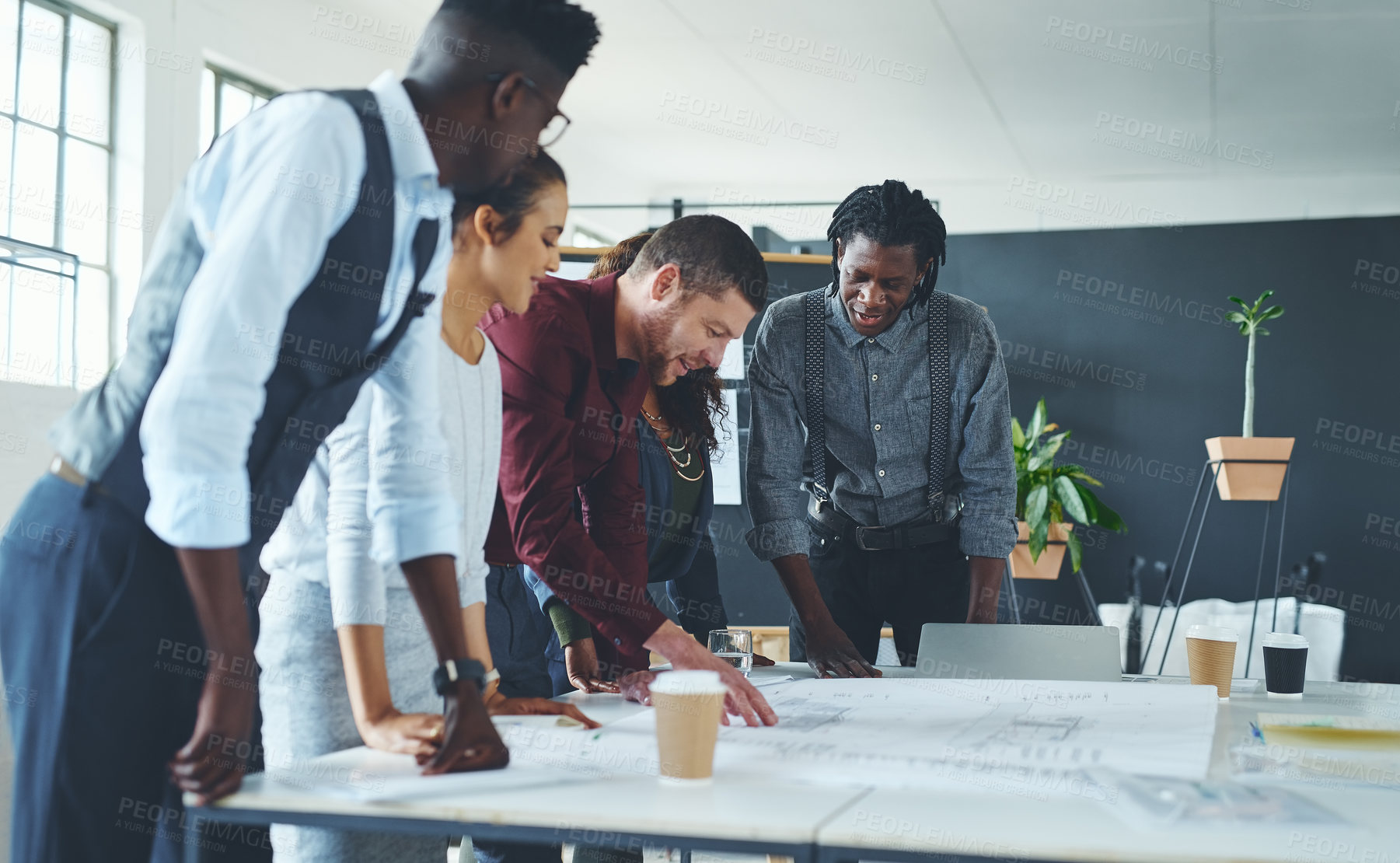 Buy stock photo Cropped shot of a team of professionals working on blueprints in an office