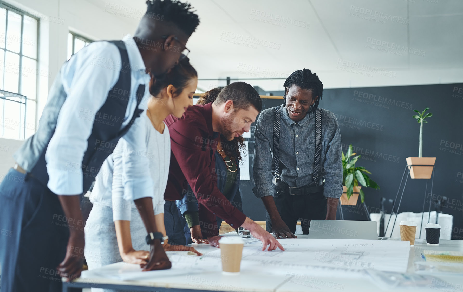 Buy stock photo Cropped shot of a team of professionals working on blueprints in an office