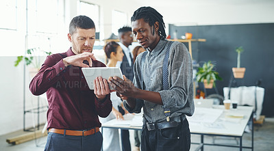 Buy stock photo Cropped shot of two businesspeople working together on a digital tablet in an office