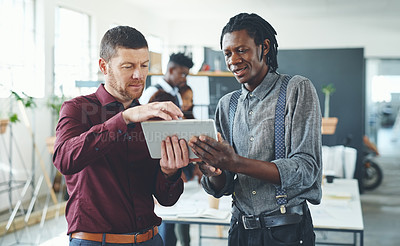 Buy stock photo Cropped shot of two businesspeople working together on a digital tablet in an office