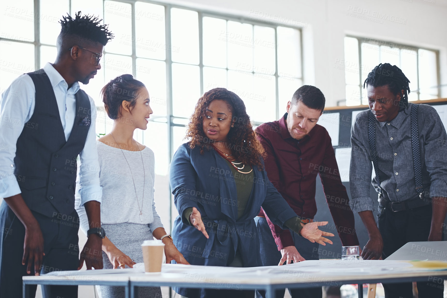 Buy stock photo Cropped shot of a team of professionals working on blueprints in an office