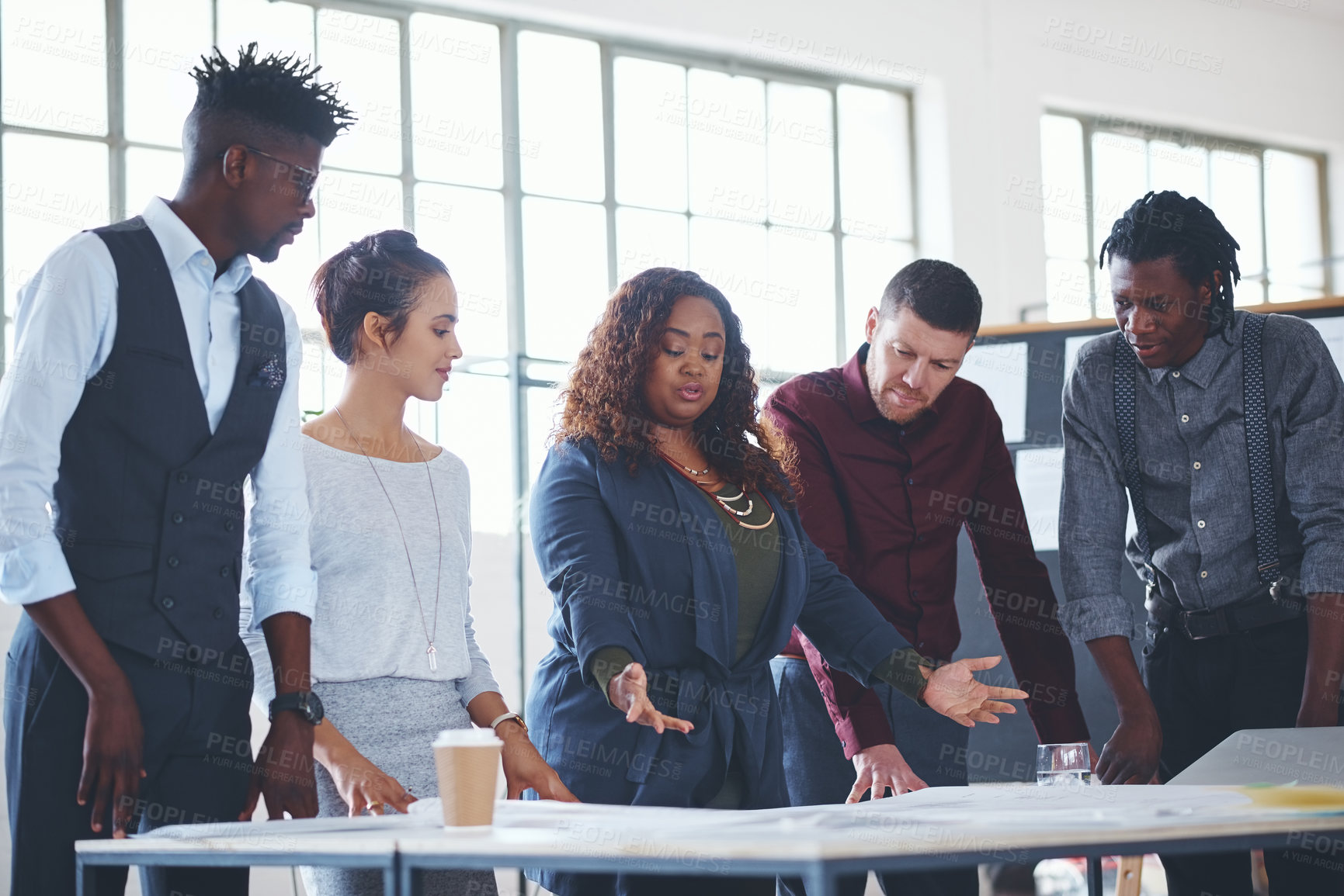 Buy stock photo Cropped shot of a team of professionals working on blueprints in an office