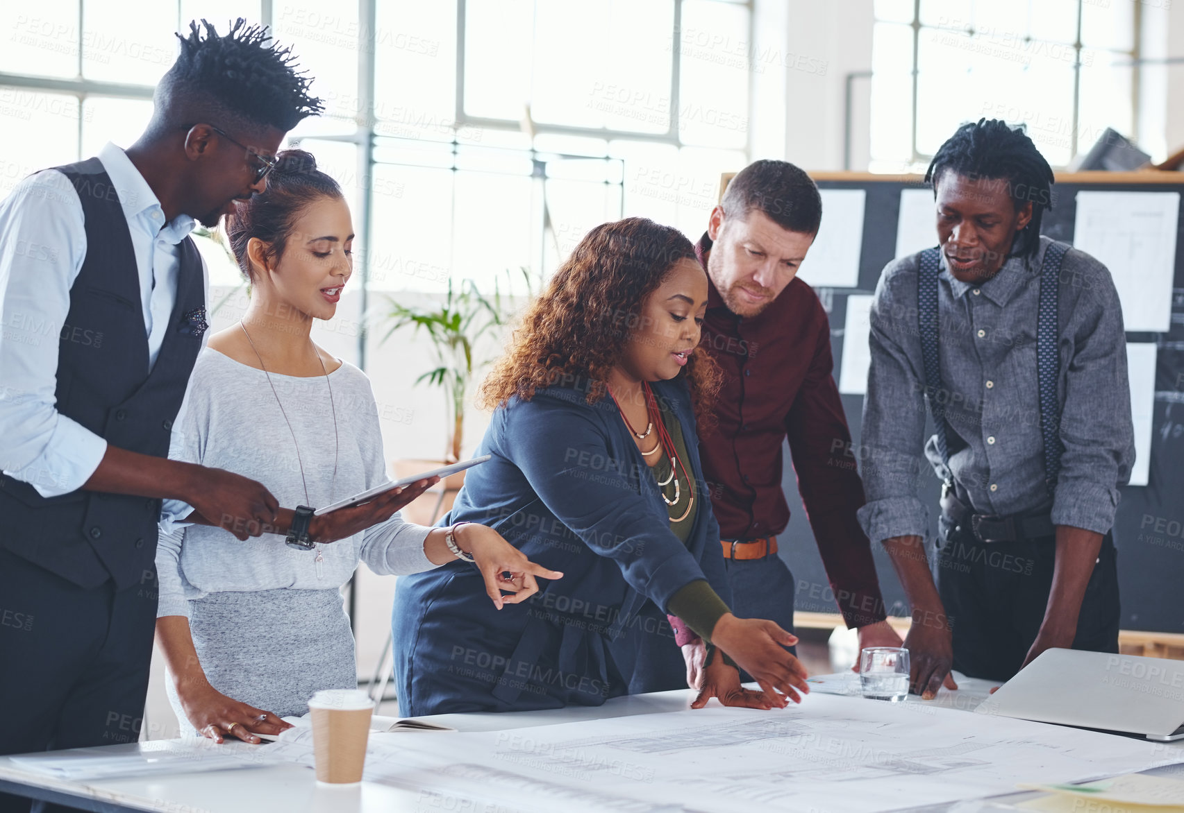 Buy stock photo Cropped shot of a team of professionals working on blueprints in an office