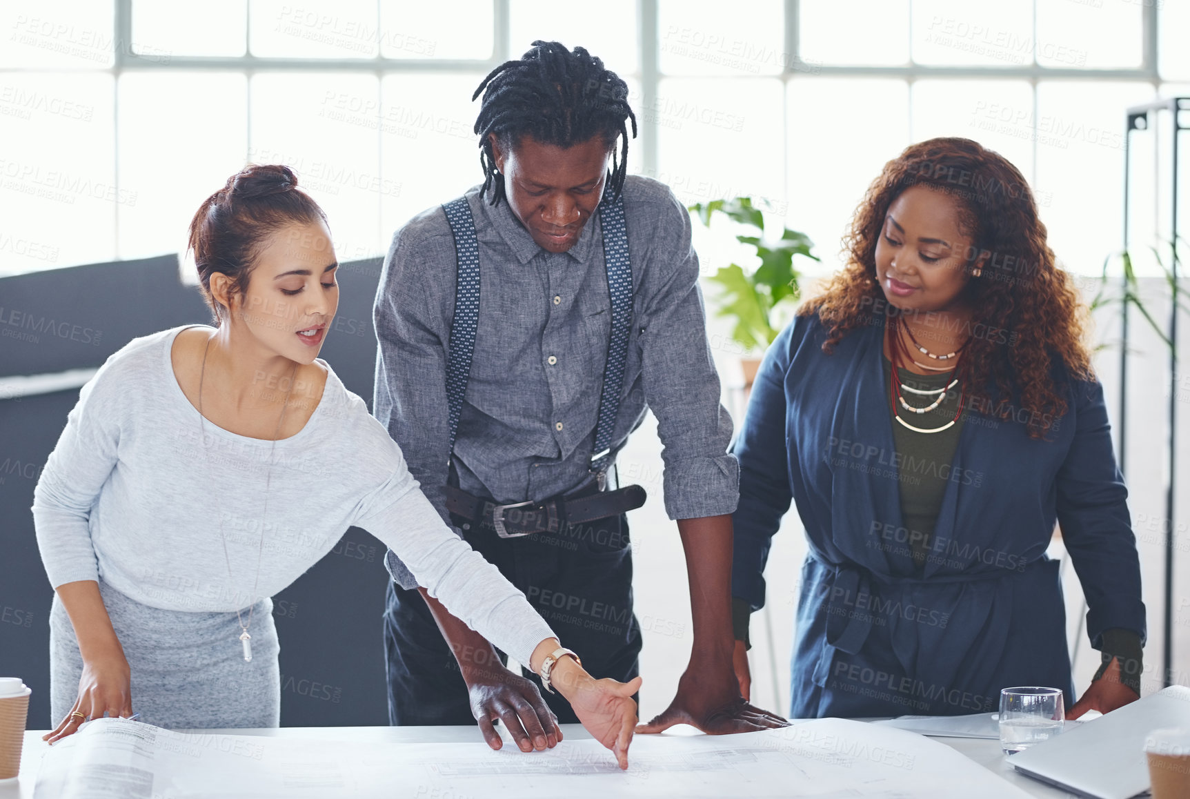 Buy stock photo Cropped shot of a team of professionals working on blueprints in an office