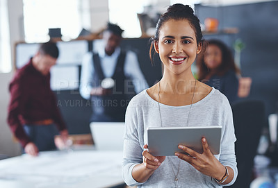 Buy stock photo Cropped portrait of an attractive young businesswoman using a tablet in the office with her colleagues in the background