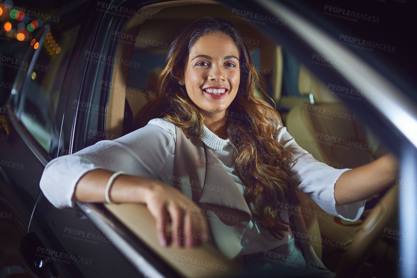 Buy stock photo Portrait of an attractive young businesswoman driving in her car at night
