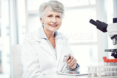 Buy stock photo Portrait of a cheerful elderly female scientist making notes while looking at the camera and smiling in a laboratory