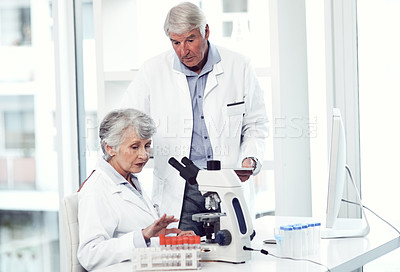 Buy stock photo Shot of two elderly and focused scientists working together inside of a laboratory