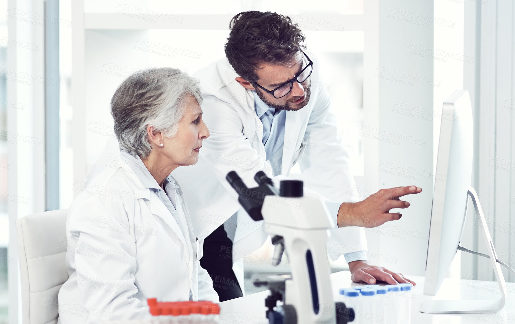 Buy stock photo Shot of two focused scientist working together on a computer inside of a laboratory