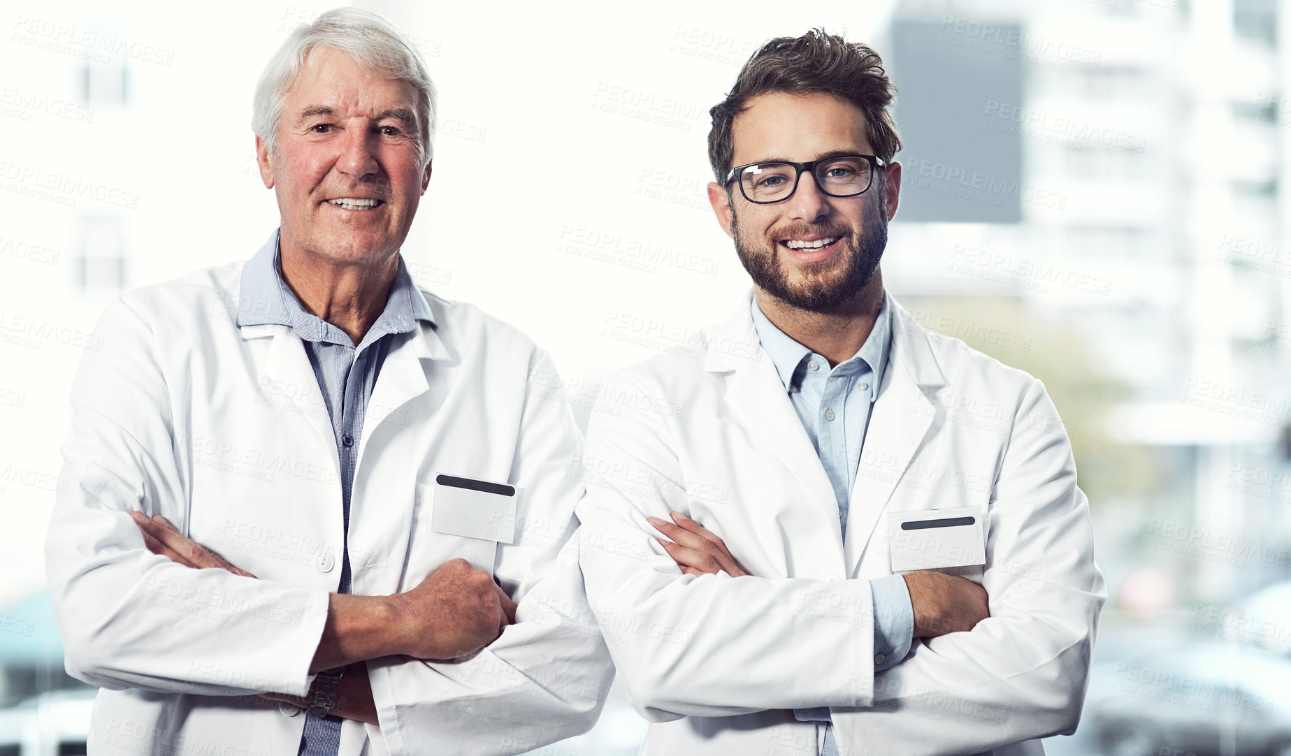 Buy stock photo Portrait of two cheerful male scientists standing with arms folded while looking into the camera inside a laboratory