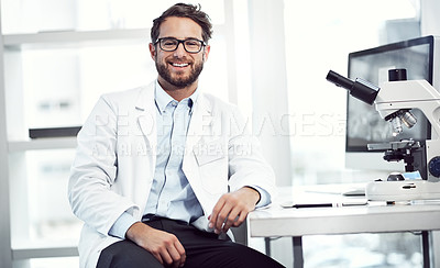 Buy stock photo Shot of a cheerful young male scientist looking into the camera while being seated inside of a laboratory