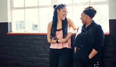 Buy stock photo Shot of two cheerful young women having a conversation before a workout session in a gym