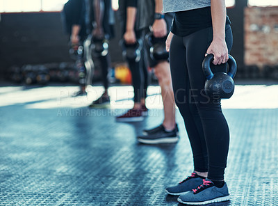 Buy stock photo Shot of a group unrecognizable people standing in a row doing training with weights in a gym