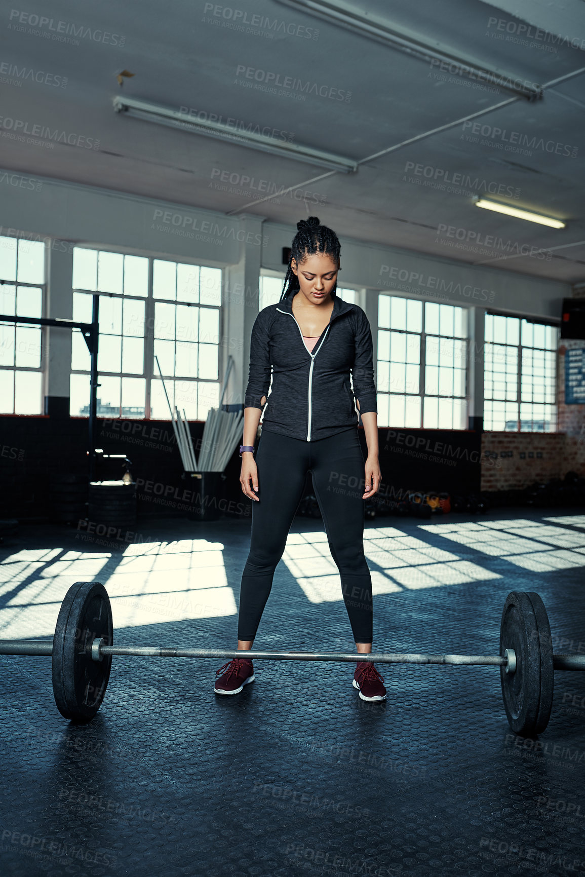 Buy stock photo Shot of a young woman getting ready to lift weights in a gym