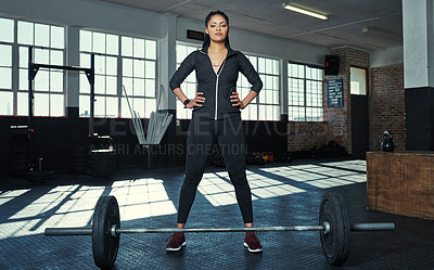 Buy stock photo Shot of a young woman getting ready to lift weights in a gym