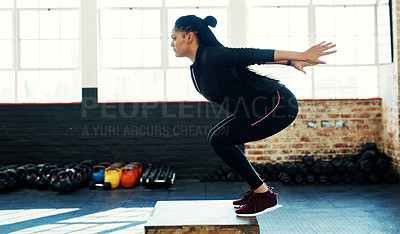 Buy stock photo Shot of a young woman doing a exercise jump on a wooden block in a gym