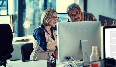 Buy stock photo Shot of two businesspeople working late in an office
