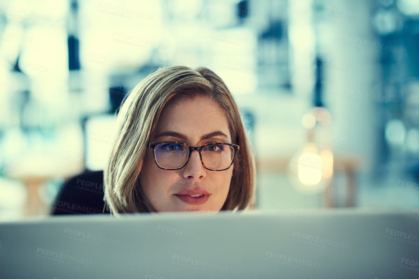 Buy stock photo Shot of a young businesswoman working late in an office