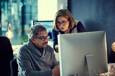 Buy stock photo Shot of two businesspeople working late in an office