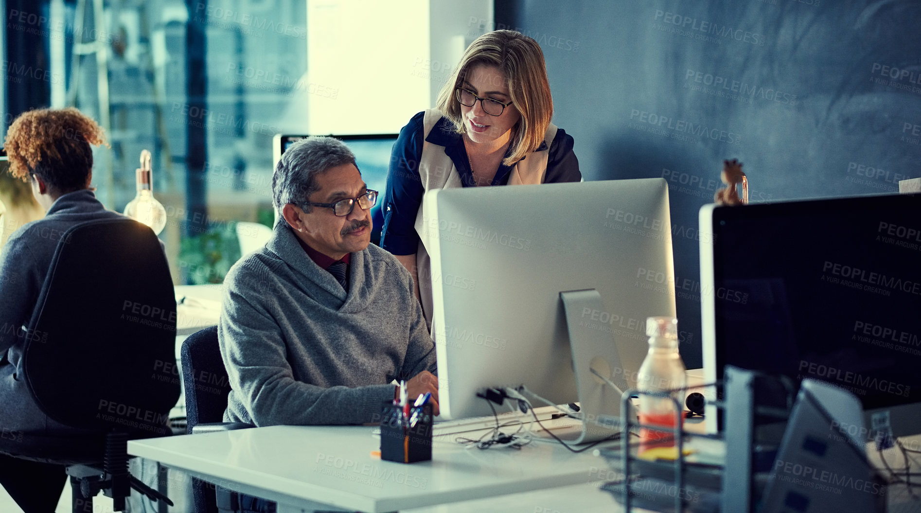 Buy stock photo Shot of a group of businesspeople working late in an office