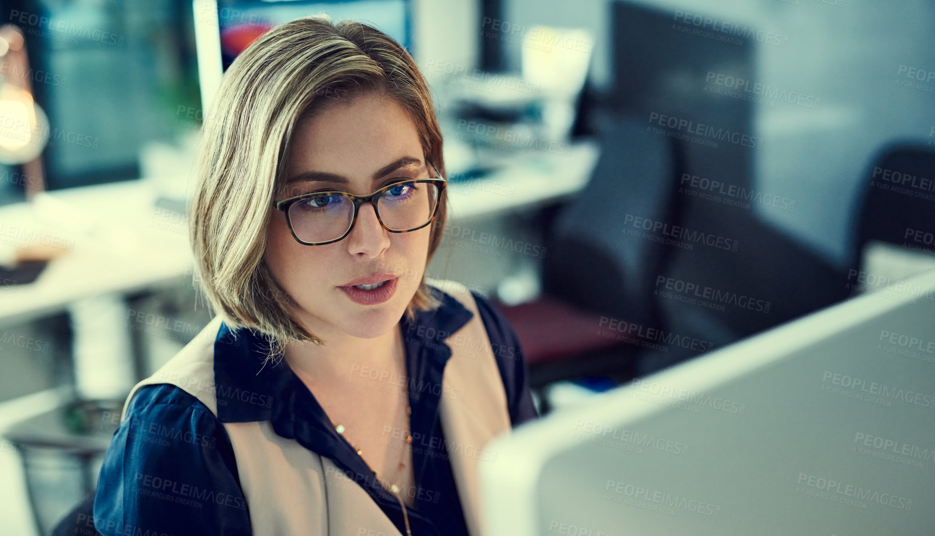 Buy stock photo Shot of a young businesswoman working late in an office